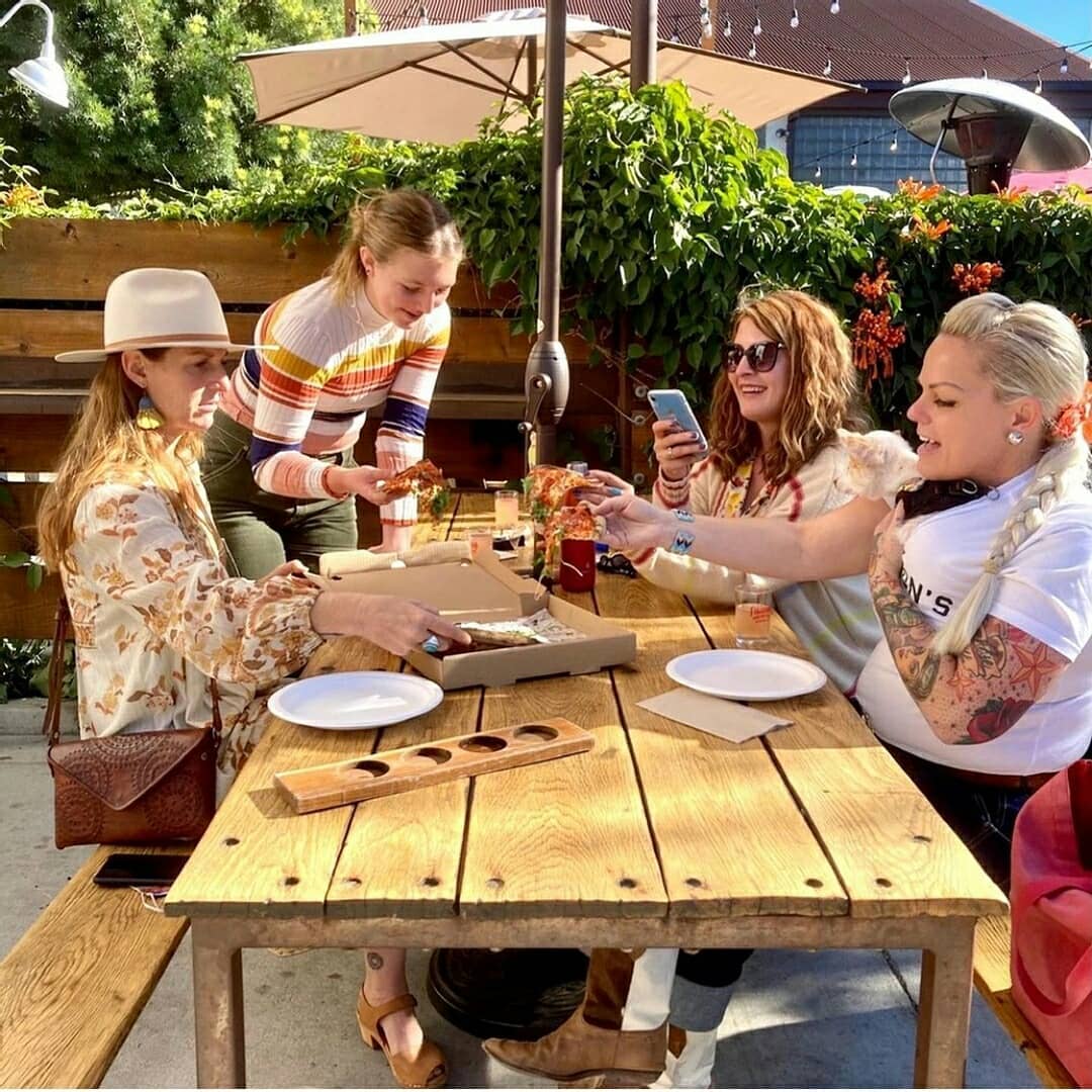 Women enjoy pizza at Lucky Penny.