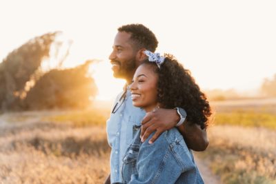 Couple hugging at Ellwood Mesa at sunset